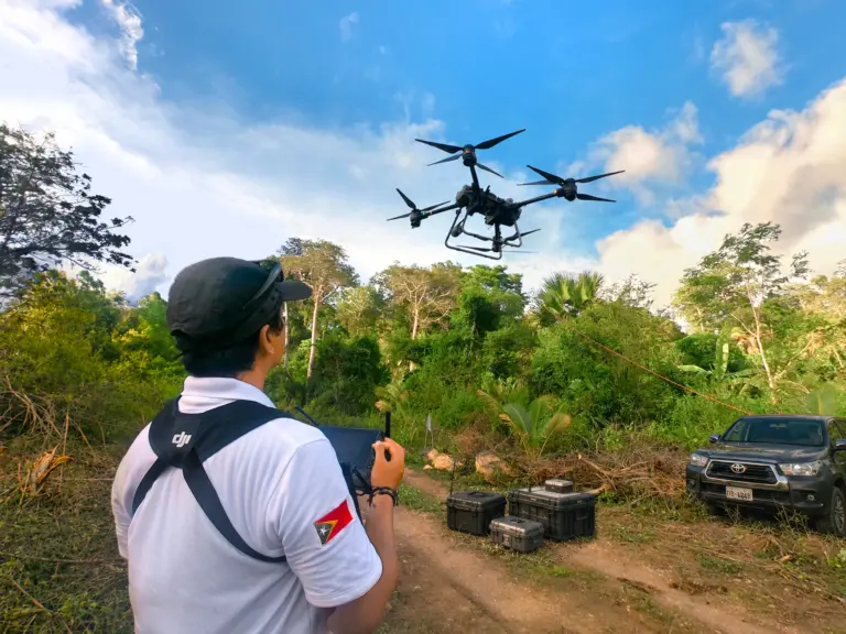 Drone pilot launching quadcopter in the jungle for survey.